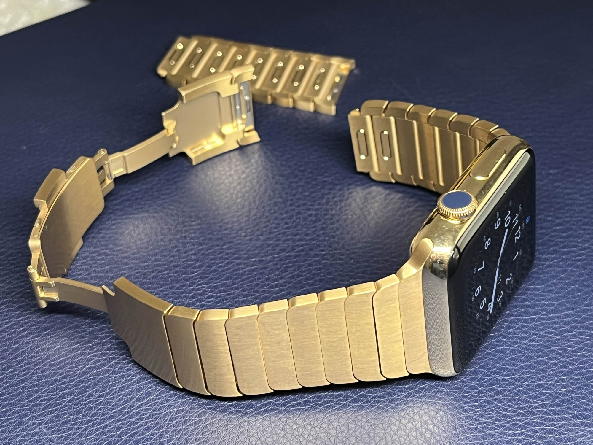18-karat gold Apple Watch and opened gold steel link bracelet